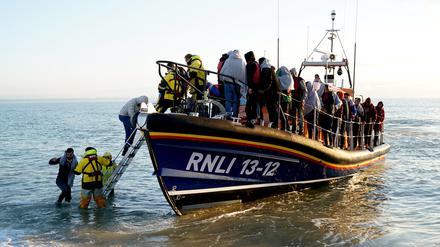 Eine Gruppe von Migranten wird von der Royal National Lifeboat Institution (RNLI) mit einem kleinen Boot im Ärmelkanal nach Dungeness gebracht.