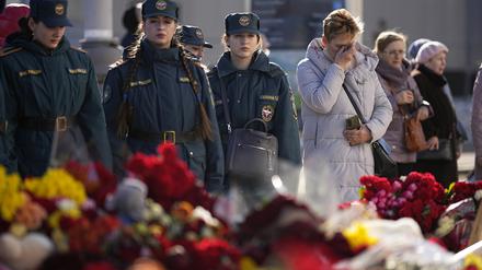 Menschen stehen an einer behelfsmäßigen Gedenkstätte für die Opfer vor dem Crocus City Hall am westlichen Stadtrand von Moskau. 