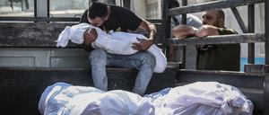 Ein palästinensischer Mann küsst die Leiche eines bei israelischen Luftangriffen getöteten Kindes auf der Ladefläche eines Fahrzeugs am Al-Shifa-Krankenhauses. 