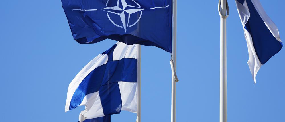 Die Nato-Flagge (M.) und die finnische Flagge flattern über dem Gebäude des finnischen Außenministeriums.
