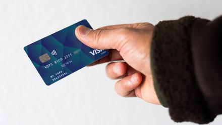  Ein Geflüchteter hält eine Debitkarte in der Hand (Symbolbild).