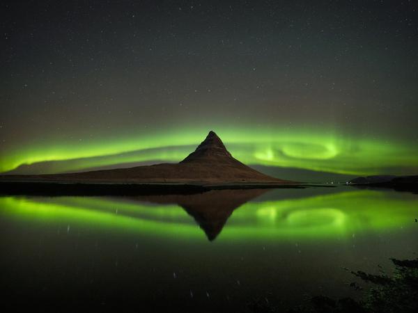 Polarlichter sind am Himmel über dem Berg Kirkjufell an der Nordküste der isländischen Halbinsel Snaefellsnes in der Nähe der Stadt Grundarfjordur zu sehen.