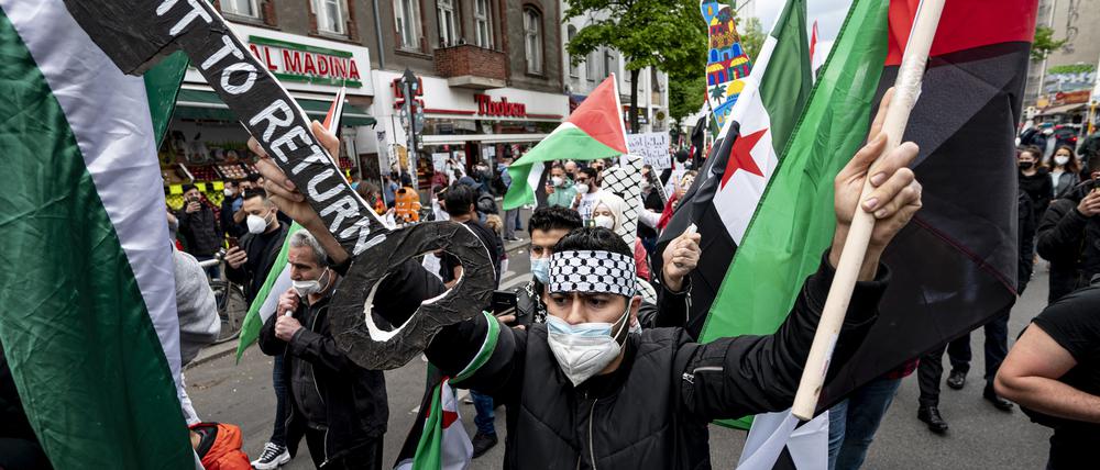 Ein Teilnehmer der Demonstration verschiedener palästinensischer Gruppen läuft und einem großen Schlüssel mit der Aufschrift „Right to Return“ durch Neukölln.  