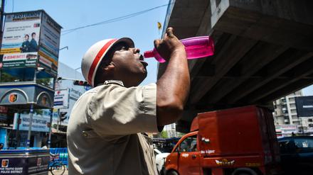 Ein Polizeibeamter aus Westbengalen trinkt während der Hitzewelle in Kolkata, Indien, Wasser.