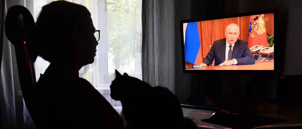 Eine Frau sieht im Fernsehen eine Ansprache des russischen Präsidenten Wladimir Putin an die Nation in Jekaterinburg.