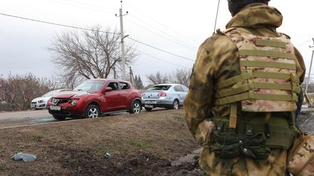 Ein Soldat schaut auf beschädigte Autos als Folge der erneuten Luftangriffe in der Siedlung Rasumnoje außerhalb von Belgorod (19. März 2024).