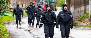 Polizisten und Polizistinnen gehen auf der Suche nach dem vermissten Arian aus Bremervörde über ein landwirtschaftliches Gelände.