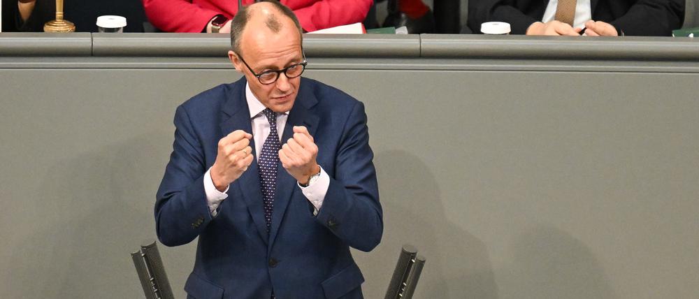 Friedrich Merz (CDU) ballt die Fäuste am Rednerpult im Bundestag. 