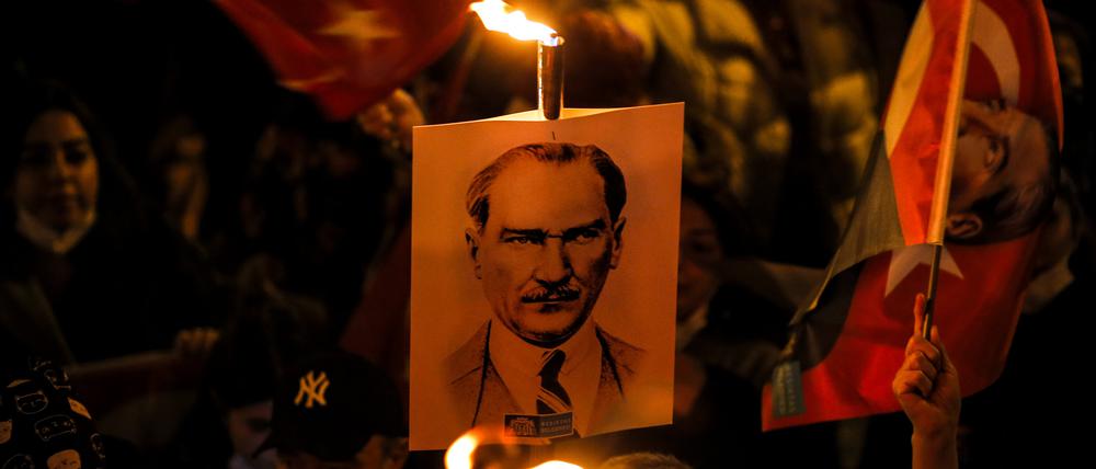 Menschen schwenken türkische Flaggen und Plakate von Mustafa Kemal Atatürk.