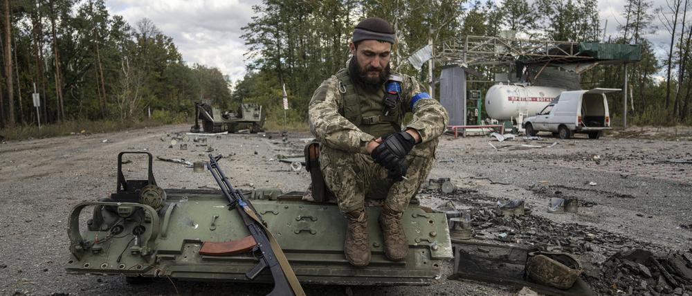 Ein ukrainischer Soldat raucht eine Zigarette, nachdem er die Leiche eines Kameraden in der kürzlich zurückeroberten Stadt Lyman, Ukraine, gefunden und identifiziert hat. 