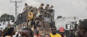 Uniformierte fahren mit einem Auto auf einer Straße durch die Stadt. Der anhaltende Konflikt im Ostkongo zwischen den Regierungstruppen und den M-23-Rebellen hat Zehntausende zur Flucht gezwungen.