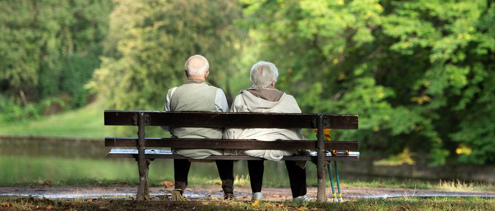Zwei Rentner sitzen auf einer Bank. 