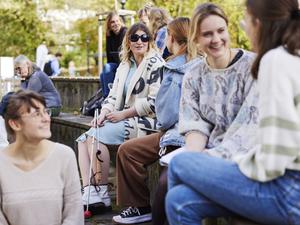 Eine Frau mit Blindenstock und Sonnebrille auf dem Campus auf einem Workshop in Dortmund zum Thema Inklusion in der Bildung. 