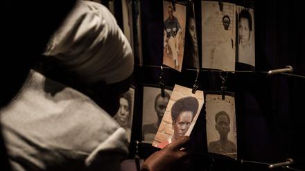 (FILES) A picture taken on April 29, 2018 shows a visitor looking at victims' portraits at the Kigali Genocide Memorial in Kigali, Rwanda. Rwanda will on April 7, 2024 commemorate the 30th anniversary of the genocide during which Hutu extremists targeting the Tutsi minority slaughtered around 800,000 people in a massacre lasting 100 days. (Photo by Yasuyoshi CHIBA / AFP)