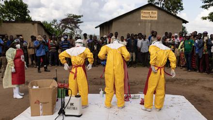 Mitarbeiter des Roten Kreuzes ziehen Schutzanzüge an, bevor sie am 13. Oktober  in Mubende einen 3-jährigen Jungen beerdigen, der wohl an Ebola verstorben ist.