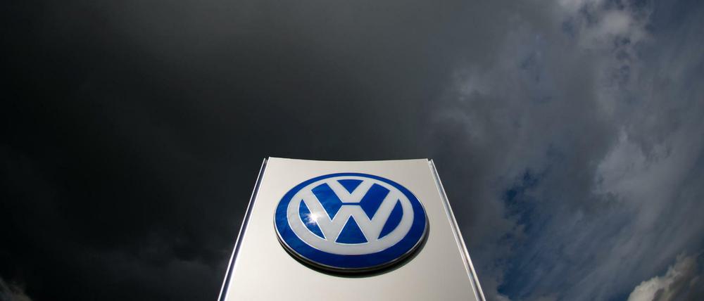 Dunkle Wolken über einem VW-Logo in Wolfsburg