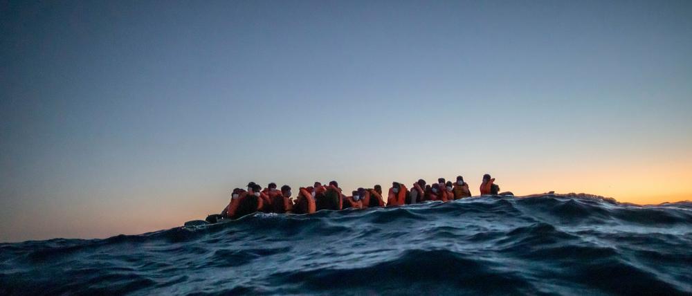 Migranten aus afrikanischen Nationen warten in einem Boot auf Helfer, 122 Meilen vor der libyschen Küste im Mittelmeer.