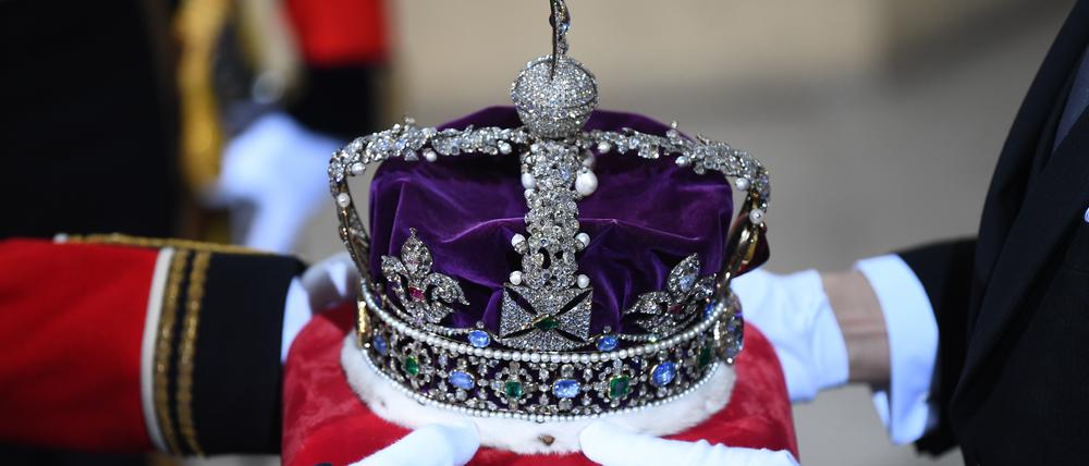 Die Krone wird im Eingang für die Monarchin zum britischen Oberhaus im Westminsterpalast anlässlich der feierlichen Wiedereröffnung des britischen Parlaments übergeben. 