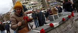 Eine Frau in Ankara legt Blumen als Gedenken auf eine Mauer. Am Sonntag waren bei einem Anschlag in Ankara 35 Menschen getötet worden