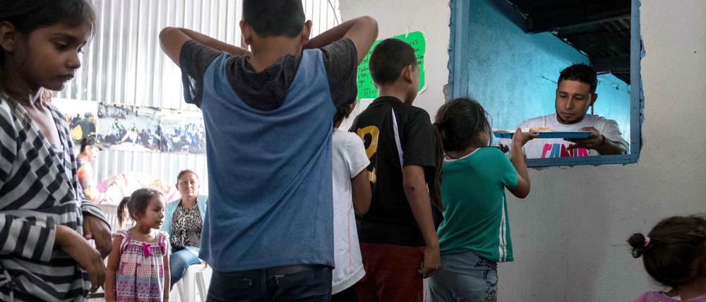 Asylum seeker children from Mexico and Central America line up for their breakfast at Juventud 2000 migrant shelter in Tijuana on June 20, 2018.US President Donald Trump said Wednesday he would sign an executive order to keep migrant families together at the border with Mexico, amid an escalating uproar over the separation of children from their parents. / AFP PHOTO / GUILLERMO ARIAS