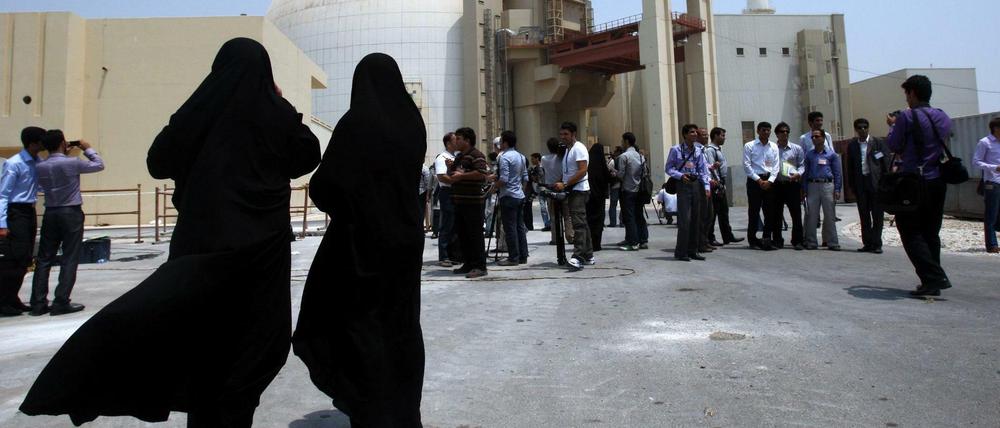 Zwei Sicherheitsbeamtinnen steht vor dem Atomkraftwerk in Buschehr im Iran und beobachten Medienvertreter (Archivbil aus 2010).