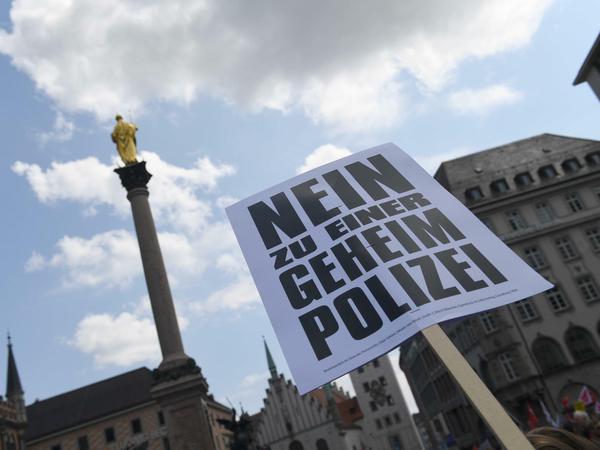 Ein Demonstrant hält bei der Demonstation auf dem Marienplatz ein Plakat hoch.