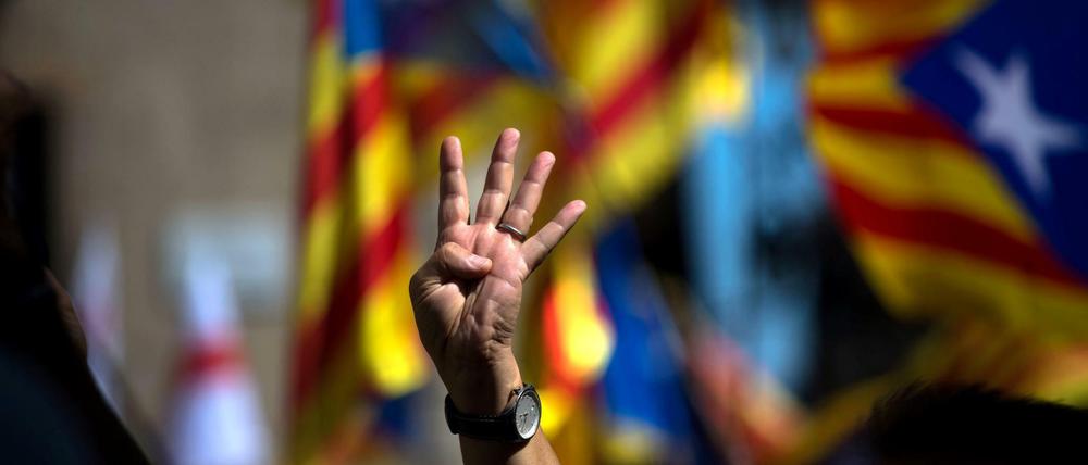 Vier Finger für die vier Balken der Estelada-Flagge, der Flagge Kataloniens. 