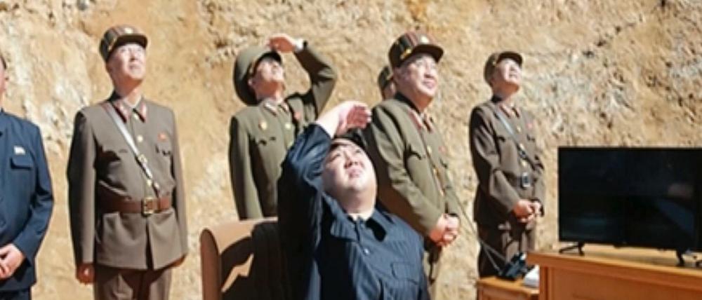 Den nordkoreanischen Machthaber Kim Jong Un (M) begutachtet einen Raketenstart. 
