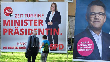 Wahlplakate der Spitzenkandidaten Boris Rhein (CDU, r), Ministerpräsident von Hessen, und Nancy Faeser (SPD), Bundesinnenministerin, stehen an einer Straße im Osten Frankfurts.