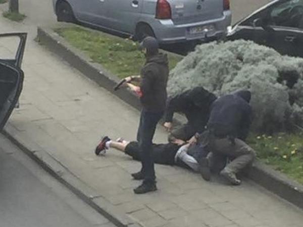 Polizisten verhaften einen Verdächtigen in Brüssel, auch Mohamed Abrini wurde bei dieser Razzia festgenommen.
