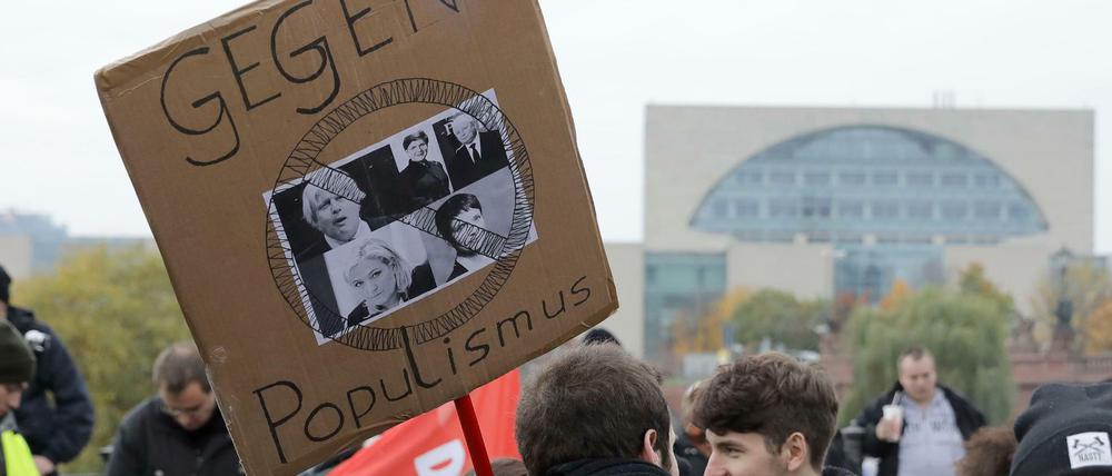 Ein Plakat mit dem Slogan "Gegen Populismus" auf einer Kundgebung vor dem Bundeskanzleramt in Berlin zu sehen.