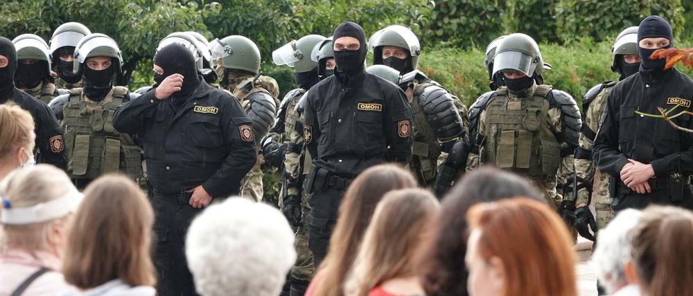 Demonstranten und Einsatzkräfte der Sonderpolizei OMON stehen sich am Unabhängigkeitsplatz in Minsk gegenüber. 