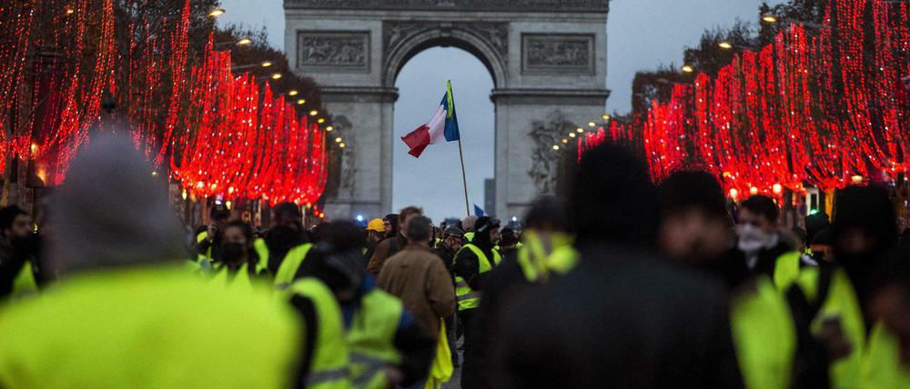 Demonstranten stehen vor dem Triumphbogen in Paris