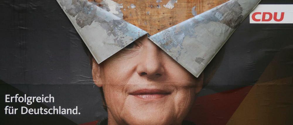 Da blättert was ab. Ein Wahlplakat mit dem Bild Angela Merkels in Bonn.