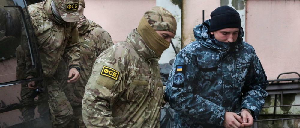 Ein ukrainischer Marinesoldat (rechts) wird nach der Festnahme im November 2018 von einem Mitarbeiter des russischen Nachrichtendienstes FSB abgeführt.