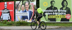 Ein Radfahrer fährt in Frankfurt am Main an Wahlplakaten mit den Spitzenkandidaten Olaf Scholz (SPD), Armin Laschet (CDU), Robert Habeck und Annalena Baerbock (Bündnis 90/Die Grünen) vorbei.