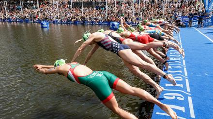 Teilnehmerinnen des Hamburg-Triathlons springen ins Wasser.