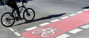 Interessante Variante. Ein Radfahrer fährt auf einer Straße neben einer rot markierten Radweg.