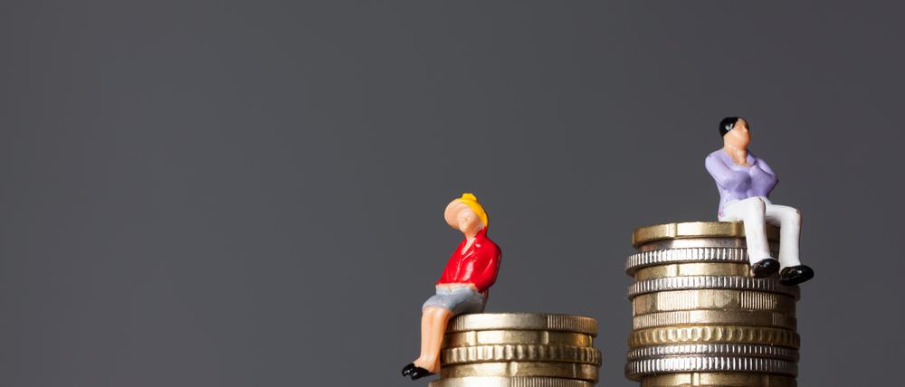 Gender pay equality concept. man and woman on a stack of coins.