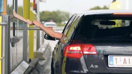 Ein Audi bezahlt an einer Maut-Stelle auf einer französischen Autobahn.