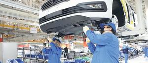 Die Produktion wird langsam hochgefahren. Arbeiter in einem VW-Werk in China.