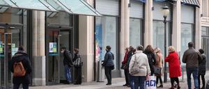 Menschen stehen vor einem Geschäft an (Archivfoto)