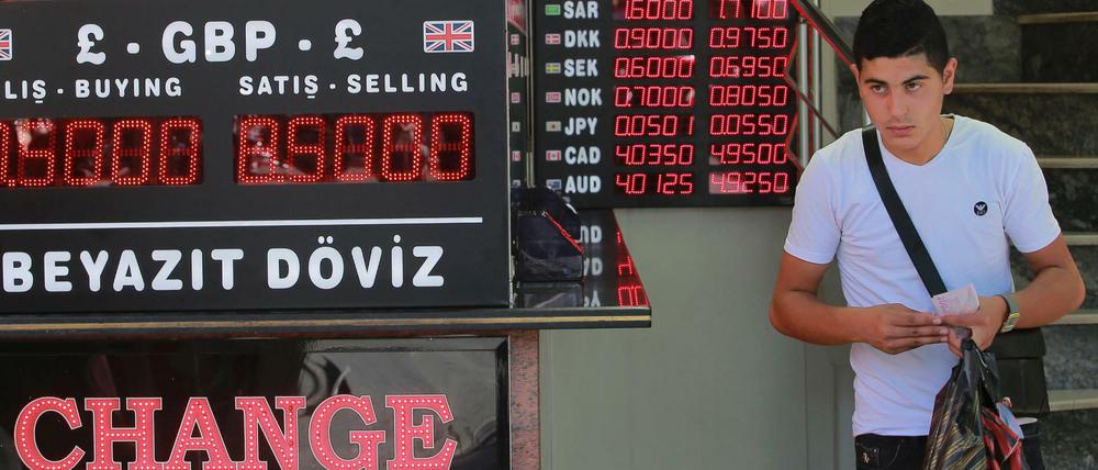 Montag, 13.08.2018, in Istanbul: Ein Jugendlicher läuft an einer Anzeigetafel mit den Wechselkursen ausländischer Währungen vorbei. Viele Türken haben Devisenkonten, um Einbußen wegen der hohen Inflation der Lira zu vermeiden.