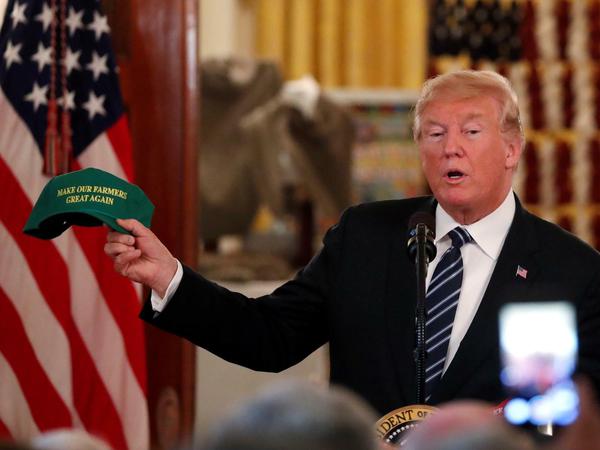 US-Präsident Donald Trump präsentiert Ende Juli 2018 in Washington eine Mütze, die er zuvor bei einer Rede von Farmer-Verbänden im Mittleren Westen geschenkt bekommen hatte. In Anlehnung an seinen Wahlspruch steht darauf: "Make Our Farmers Great Again".