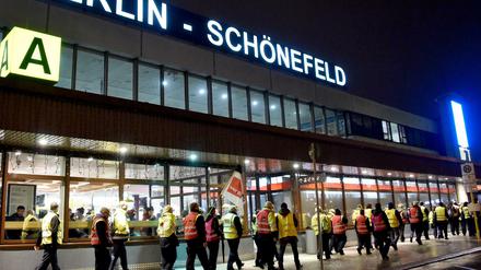 Streikendes Sicherheitspersonal geht am Flughafen Schönefeld am Hauptterminal vorbei. 
