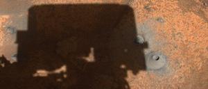 Das Bohrloch des ersten Probenentnahmeversuchs von Perseverance ist neben dem Schatten des Rovers zu sehen.