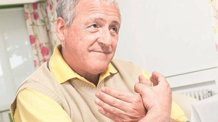 Ein älterer Mann verschränkt seine Hände bei einem einfachen Demenz-Test beim Hausarzt.