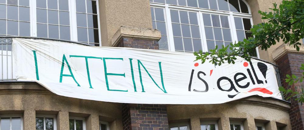 Auf einem Banner an der Fassade einer Berliner Schule steht "Latein is' geil".