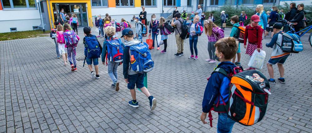 Kinder gehen am Montag in eine Schule in Schwerin.