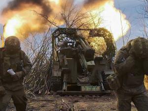 Russische Soldaten feuern an einem Geschütz.